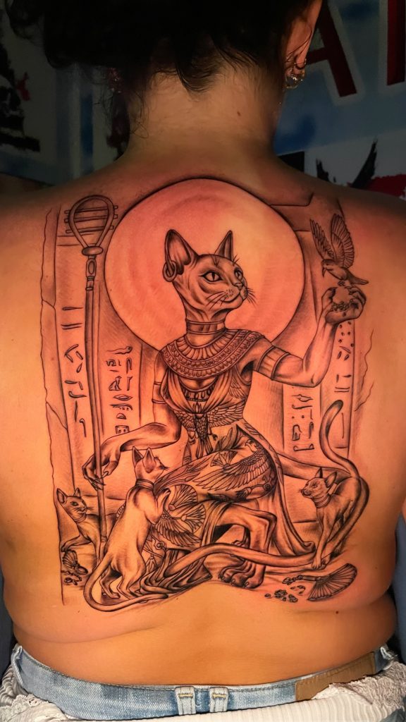 Egyptian Bastet cat goddess back tattoo in black and grey with hieroglyphics and cats — Hurghada, Egypt” “